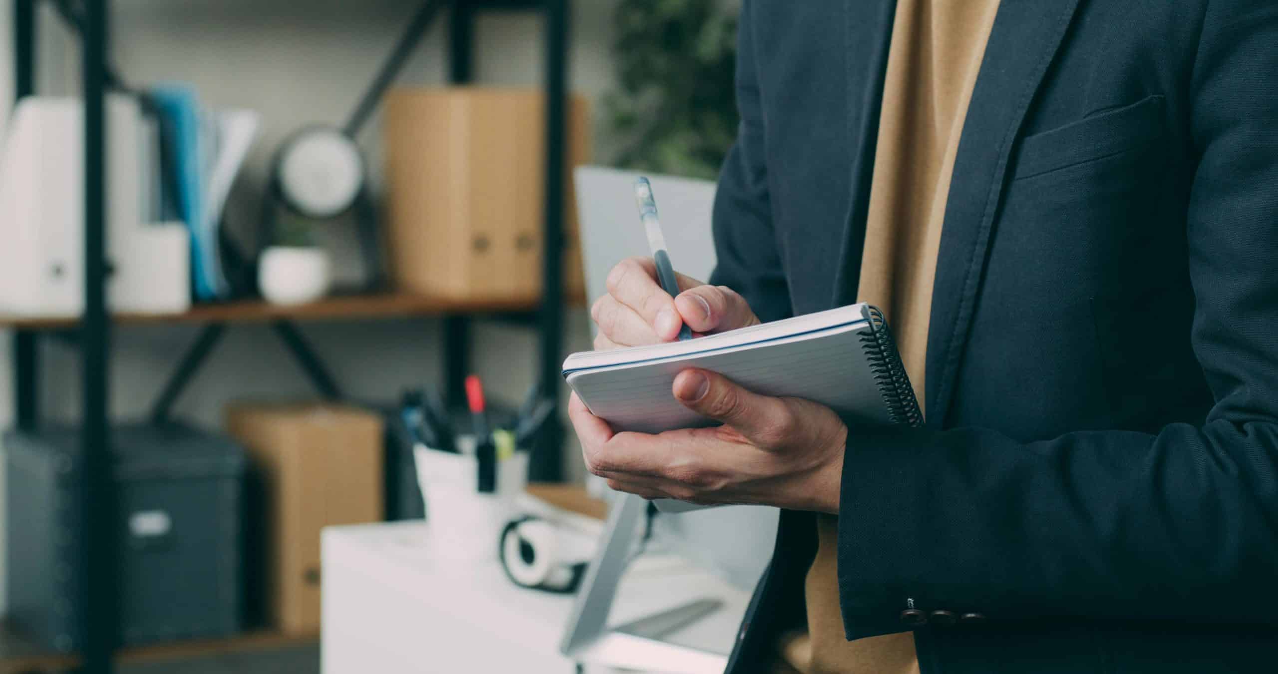 Employer in an office holding a note book